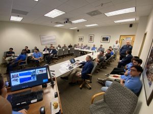 Man giving a speech to a group of people in a conference room