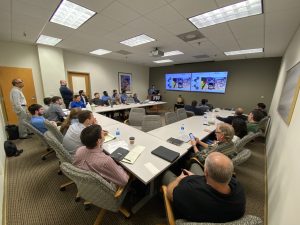 Man giving a speech to a group of people in a conference room