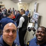 2 smiling men taking a selfie at the conference room