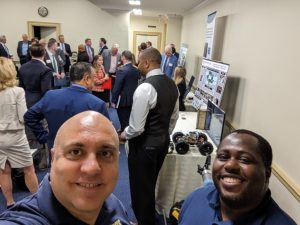 2 smiling men taking a selfie at the conference room